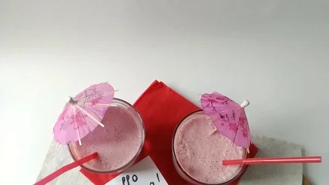 Two glasses fruit smoothies milkshake moving down Stock Footage 109498971