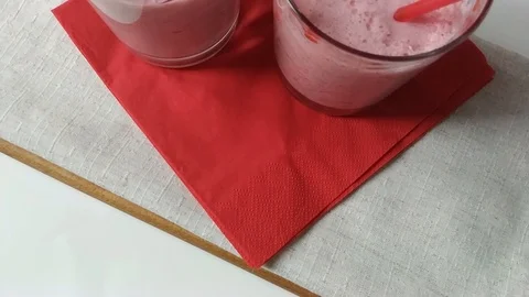 Two glasses fruit smoothies milkshake moving down Stock Footage 109499648
