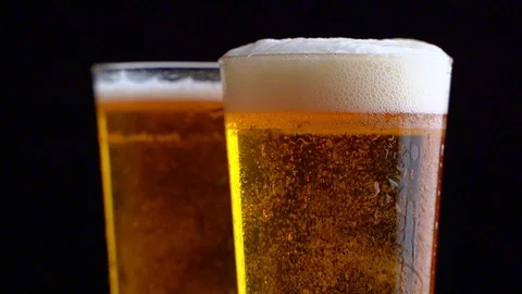 Two glasses full of beer on table with black background 動画素材 126549613