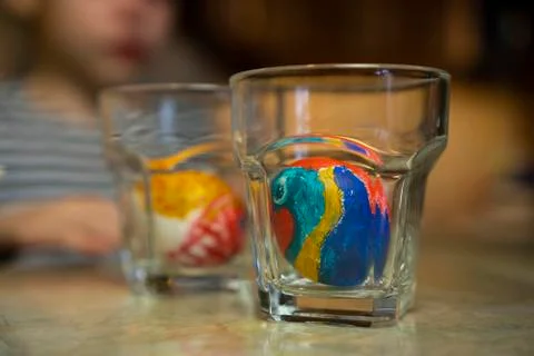 Two glasses with hand painted easter eggs at home kitchen table. Arts and Crafts Stock Photos