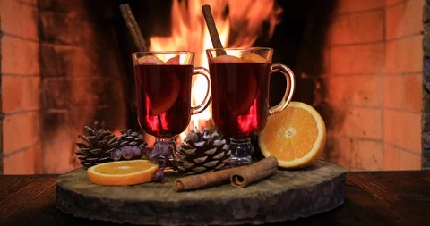 Two glasses of hot mulled wine with spices on wooden table against fireplace. Vídeo Stock 121615271