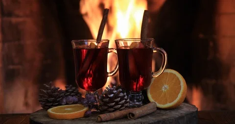 Two glasses of hot mulled wine with spices on wooden table against fireplace. 스톡 동영상 121616230
