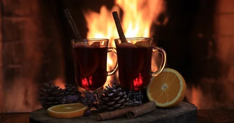 Two glasses of hot mulled wine with spices on wooden table against fireplace. Vídeos de archivo 121617174