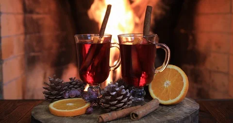 Two glasses of hot mulled wine with spices on wooden table against fireplace. Vídeo Stock 121618013