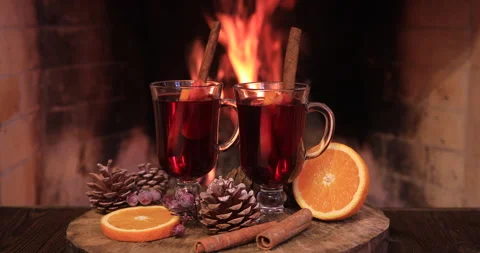 Two glasses of hot mulled wine with spices on wooden table against fireplace. Stock Footage 163548216