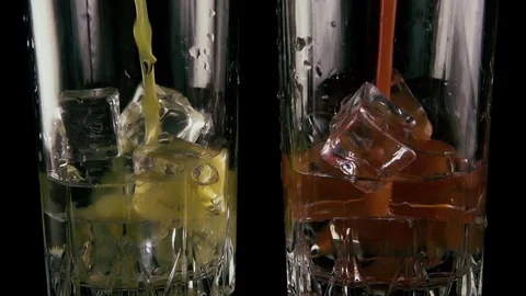 Two glasses of ice and vodka pour juice. Slow motion Stock-Footage 76434618