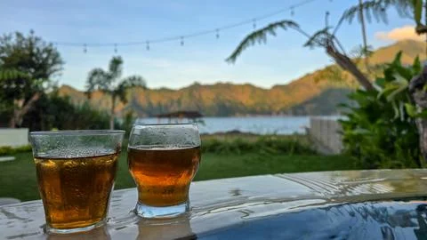 Two Glasses of Iced Tea on Infinity Pool Edge with Scenic Lake and Mountain View Stock Photos