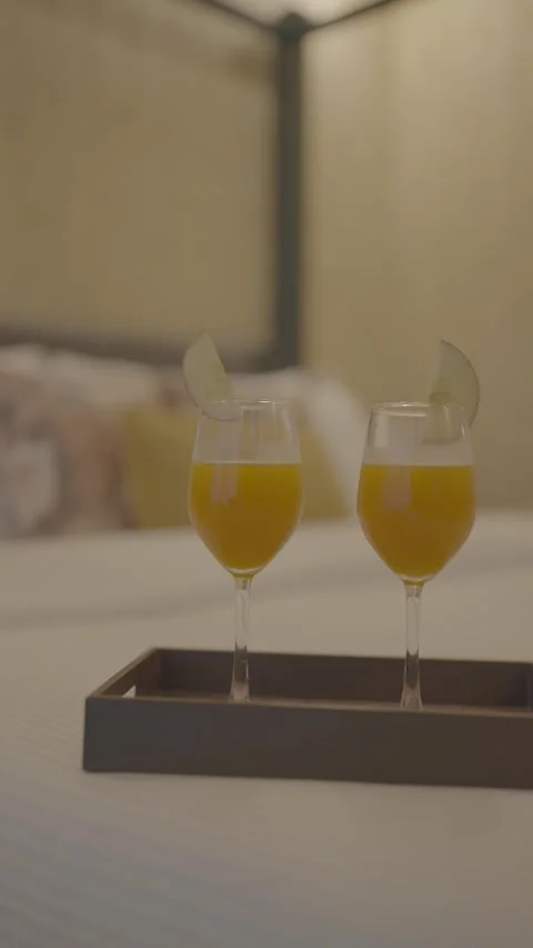 Two glasses of juice on white bed in wooden tray Stock Footage 313029759