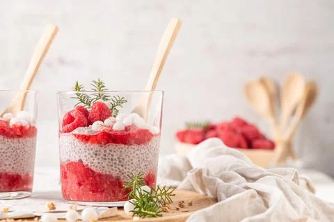 Two glasses of layered raspberry and chia seed pudding topped with fresh ra.. Stock Photos