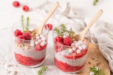 Two glasses of layered raspberry and chia seed pudding topped with fresh ra.. Foto stock