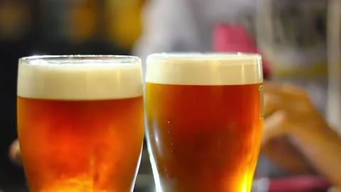 Two glasses of light refreshment beer with thick foam on table in pub, close up 스톡 동영상 208438701