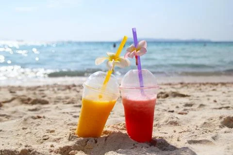 Two glasses with mango juice and watermelon juice on the beach. Stock Photos