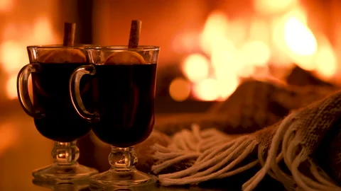 Two glasses with mulled wine and plaid on the fireplace background. Video stock 166394612