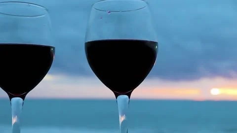 Two Glasses on the Ocean Beach. Glasses with Red Wine for a Romantic Date. Stock Footage 231141821