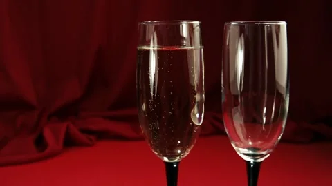 Two glasses, one full, the other empty. Filling the glass with champagne, Stock Footage 85583064