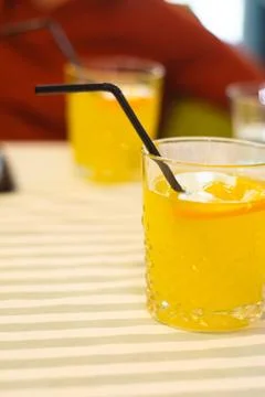 Two glasses with orange lemonade on the table in a cafe. Stock Photos