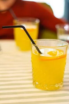 Two glasses with orange lemonade on the table in a cafe. Stock Photos