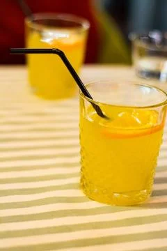 Two glasses with orange lemonade on the table in a cafe. Stock Photos