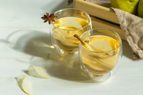 Two glasses of pear cider on a light wooden table and a box of pears in the Stock Photos