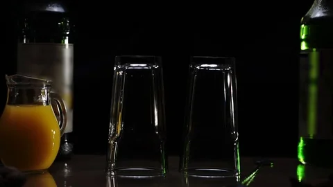 Two glasses put on a table between bottles with syrup. Stock Footage 93970580