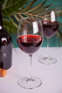 Two glasses with red grape wine with bottle on the background. Romantic dinne 库存照片
