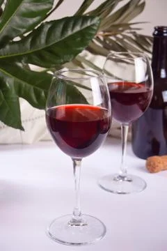 Two glasses with red grape wine with bottle on the background. Romantic dinne Stock Photos