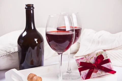 Two glasses with red grape wine with bottle and gift box on the background. R Stock Photos
