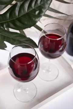 Two glasses with red grape wine with bottle on the background. Romantic dinne Stock Photos