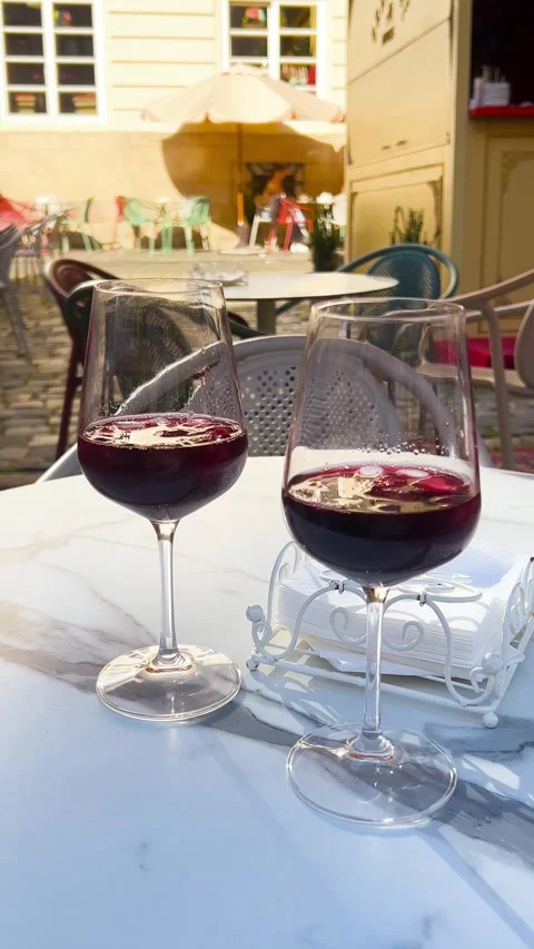 Two glasses of red sangria with ice cubes stand on a white tablecloth. Video stock 339085258