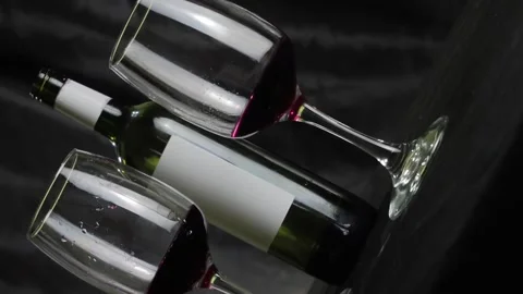 Two glasses of red wine and a bottle are on the table. Black background Vídeo Stock 146635785