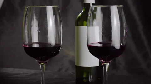 Two glasses of red wine and a bottle are on the table. Black background Vídeo Stock 146638811