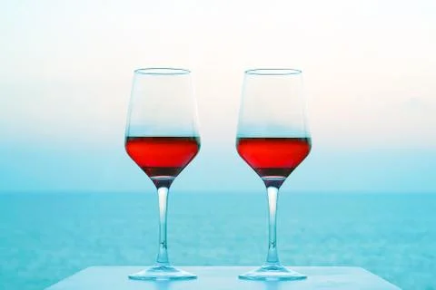 Two glasses of red wine on the background of the sea. Stock Photos