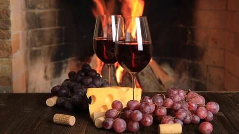 Two glasses of red wine with cheese and grapes near the fireplace. Stock-Footage 121308598