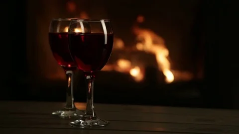 Two glasses of red wine in front of the fireplace. 스톡 동영상 72686729