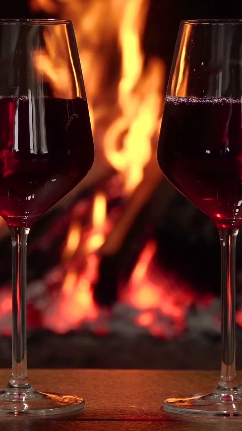 Two glasses of red wine in front of a fireplace Stock Footage 308361788