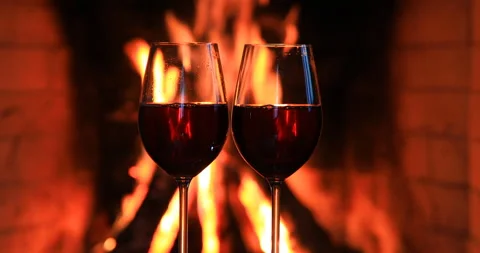 Two glasses of red wine near a fireplace Видео 85972299