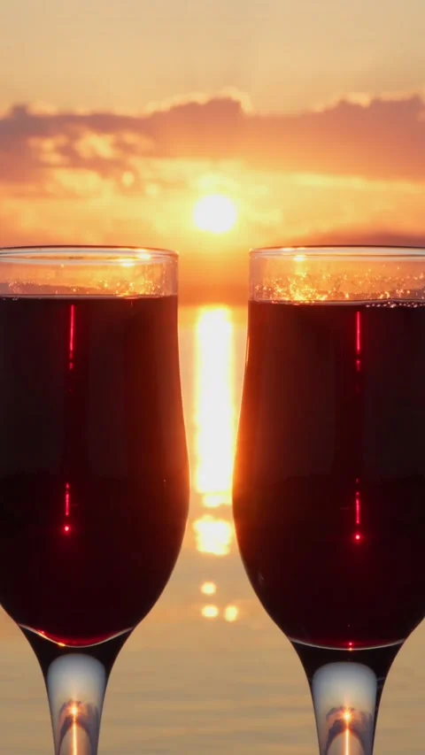 Two glasses of red wine on the shore of the lake at sunset. Stock Footage 267647288
