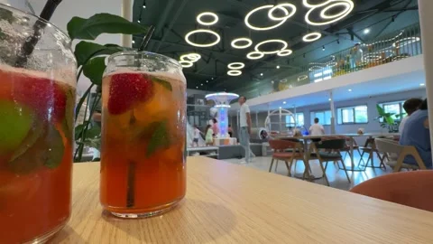 Two glasses of refreshing fruit-infused drinks sit on a wooden table Stock Footage 311649150