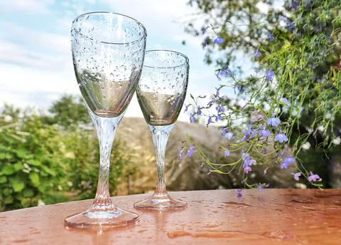 Two glasses of Roma stand on the table against the backdrop of the sunset Stock Photos
