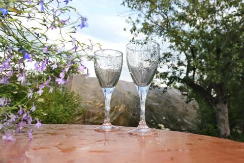 Two glasses of Roma stand on the table against the backdrop of the sunset Stock Photos