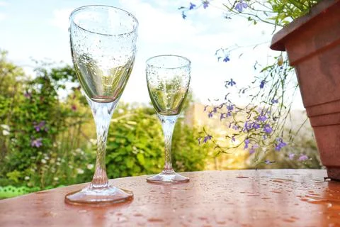 Two glasses of Roma stand on the table against the backdrop of the sunset Stock Photos
