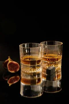Two glasses for rum with granite cubes for cooling on a dark background Stock Photos