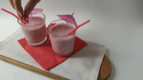 Two glasses smoothie milkshake assembly strawberry Video stock 109496874