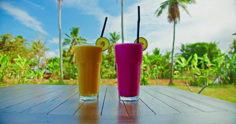 Two glasses of smoothies pudding with mango and dragon fruit banana on wooden 스톡 동영상 226834556