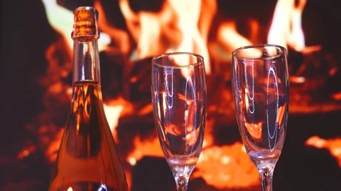 Two glasses of sparkling champagne in front of warm fireplace. C. Christmas Video stock 100609763