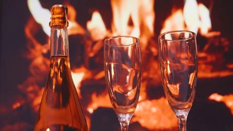 Two glasses of sparkling champagne in front of warm fireplace. valentines day Stock Footage 100611028
