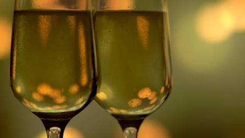 Two glasses with sparkling champagne over abstract golden blinking background. Stock Footage 111440967
