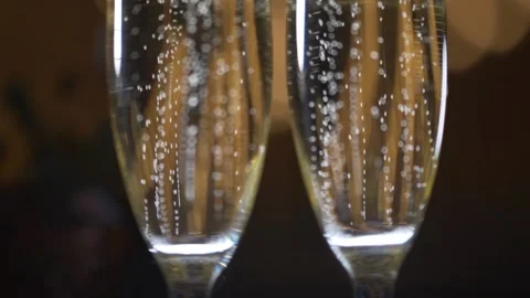 Two glasses with sparkling champaign with bubbles stand on the soft background Stock Footage 174414533