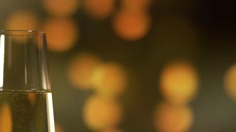 Two glasses with sparkling wine over abstract golden blinking background. Stock Footage 111038243