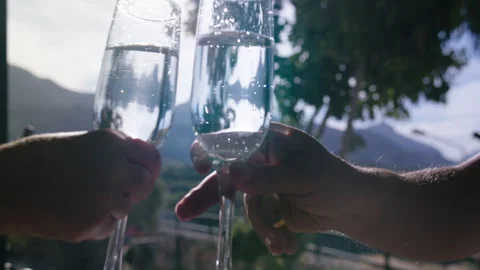 Two Glasses of Sparkling Wine Toasting Together with Breathtaking Mountain View Stock Footage 329931069